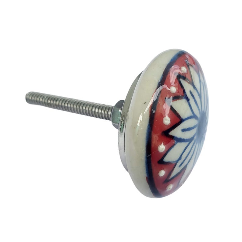 May include: A decorative ceramic cabinet knob with a floral design. The knob features a white base with a red and blue floral pattern. The metal screw extends from the back of the knob.