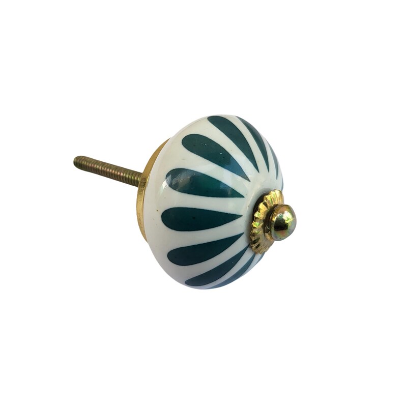 May include: A decorative cabinet knob with a white base and dark teal leaf-like patterns. The knob has a brass-colored base and screw, and is designed for easy installation. This hardware is ideal for adding a touch of elegance to furniture.
