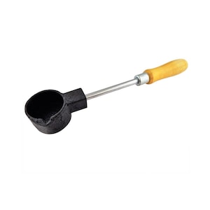 May include: A black metal ladle with a round bowl and a long, silver handle. The handle ends with a wooden grip. This tool is likely used for melting or pouring materials.