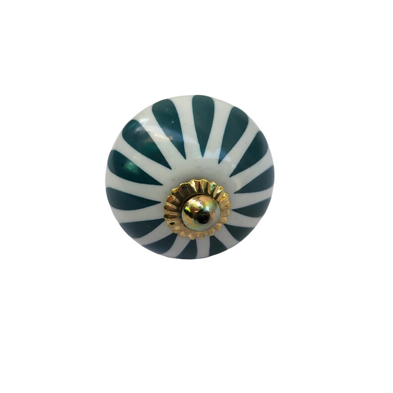 May include: A round, decorative cabinet knob with a white base and dark teal, fan-like stripes. The knob features a gold-colored metal base and a central screw. This hardware is suitable for drawers and cabinets.