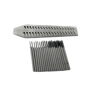 May include: A set of metal tools for precision work. The image shows a silver metal gauge with numbered holes from 0 to 16, and a set of matching metal tools. The tools are designed for detailed tasks.