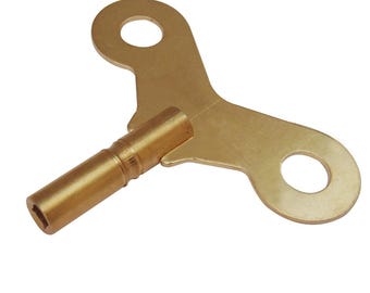 May include: A gold-colored metal wind-up key with a T-shaped handle and a square-shaped shaft.