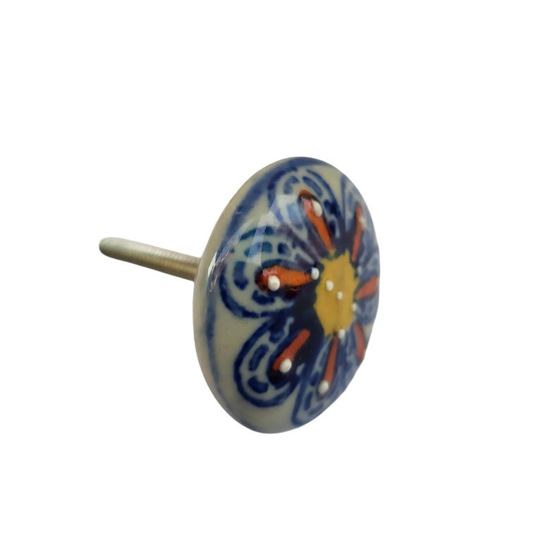 May include: A ceramic cabinet knob with a floral design. The knob is primarily blue with orange and yellow accents. The knob has a silver-colored screw for attachment.
