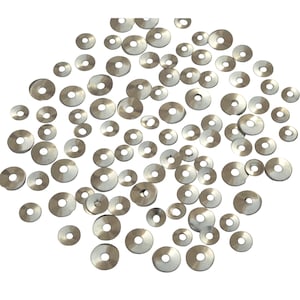 May include: A scattering of silver sequins in various sizes, perfect for crafting and embellishing projects.