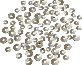 May include: A scattering of silver sequins in various sizes, perfect for crafting and embellishing projects.