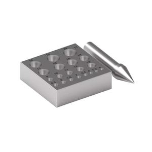 May include: A silver metal forming block with numbered holes of varying sizes, ranging from 5.5 to 20. A silver metal cone-shaped tool is positioned next to the block. The block is used for shaping metal.