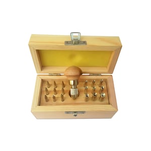 May include: A wooden box containing a set of 20 metal tools with different sized tips. The tools are used for leather crafting and are stored in a wooden box with a hinged lid.