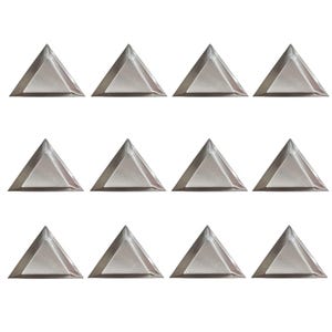 May include: Twelve silver-colored, pyramid-shaped metal studs arranged in three rows of four. Each pyramid has a flat base and angled sides, reflecting light. The studs are likely for decorative purposes, such as embellishing clothing or accessories.