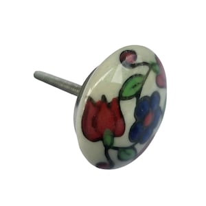 May include: Oval ceramic cabinet knob with a floral design. The knob features a cream-colored base with red, blue, and green floral accents. The metal screw is silver. This decorative knob is suitable for drawers and cabinets.
