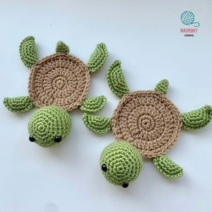 May include: Two crocheted turtle coasters. The turtles are green with brown shells and black eyes. The coasters are handmade by Naiminy.