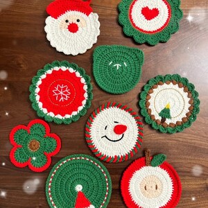 Puede incluir: Una colección de posavasos navideños hechos a mano y tejidos a ganchillo. Los diseños incluyen a Papá Noel, un muñeco de nieve, un árbol de Navidad, un copo de nieve, un corazón y una flor. Los posavasos son principalmente rojos, blancos y verdes, con costuras detalladas.