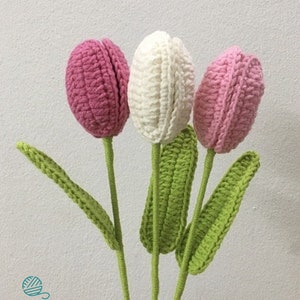 May include: Three crocheted tulips in pink, white, and light pink with green crocheted stems and leaves.