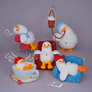 May include: Five crocheted white duck figures with orange beaks and feet. One sits in a red chair, one in a blue chair, one in a tea cup, one leans on a red chair, and one stands with a coffee cup hanging from a metal stand. Includes line art.