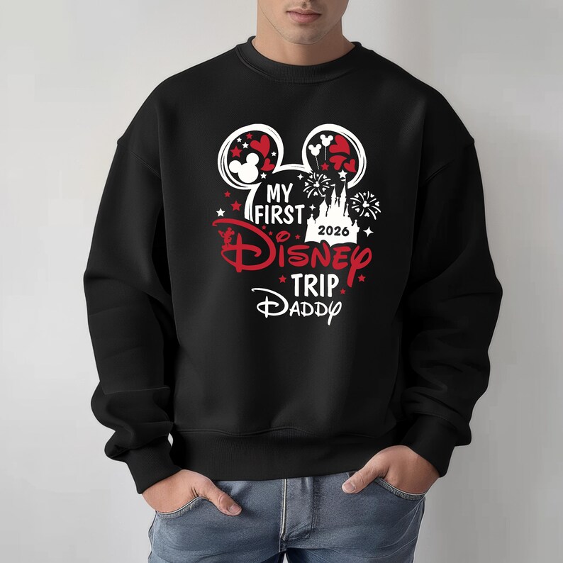 May include: Black sweatshirt with a Disney-themed graphic. The design includes Mickey Mouse ears, fireworks, stars, and the text "MY FIRST Disney TRIP DADDY 2026" in red and white.