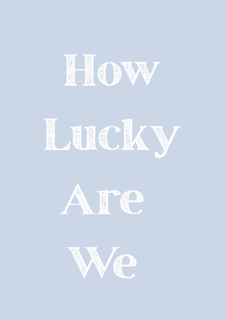 May include: A light blue background with the white text "How Lucky Are We" in a distressed font. The text is vertically centered, creating a simple and elegant design.