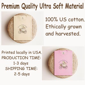 May include: Two t-shirts, one beige and one pink, each with a whimsical illustration of a frog on a bicycle. The beige shirt is on a woven mat. The pink shirt is also on a woven mat. The text on the shirts reads "all to come a kartoffel at anytime".