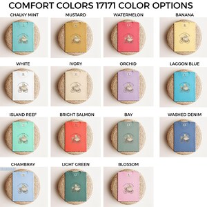 May include: A selection of Comfort Colors t-shirts in shades like Chalky Mint, Mustard, Watermelon, and Banana. Each tee displays a bicycle-riding graphic. The text "COMFORT COLORS 17171 COLOR OPTIONS" is visible at the top of the image.