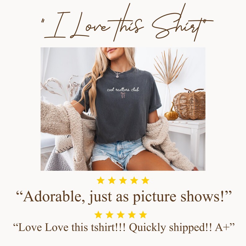 May include: A charcoal gray short-sleeve t-shirt featuring the white text "cool realtors club" printed on the chest, accompanied by a small, simple line-drawn bow graphic positioned directly beneath the text in a light pink color.