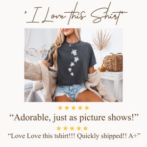 May include: Dark gray t-shirt featuring a white turtle design. The shirt has the text "I Love this Shirt" at the top. The shirt is worn with denim shorts and a beige jacket. The image also includes text that says "Adorable, just as picture shows!"