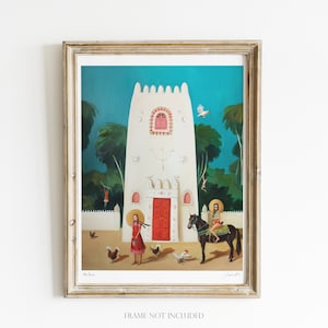 May include: A colorful painting of a white building with a red door, surrounded by trees and a woman riding a horse. The painting is framed in a light wood frame.