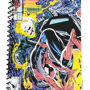 Puede incluir: Cuaderno con espiral con portada de cómic "SPIDER-MAN". La ilustración dinámica muestra a Spider-Man, Ghost Rider y el Duende Verde en acción, con colores brillantes y texto. La portada incluye detalles de la edición.