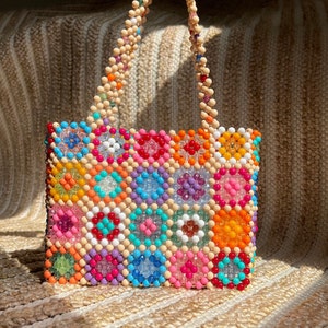 May include: A colorful beaded handbag with a geometric pattern. The bag is made of small, colorful beads that are woven together to create a unique and eye-catching design.