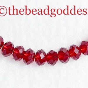 May include: A strand of deep red faceted glass beads. The beads are strung on a clear thread and are approximately 6mm in diameter.  ©thebeadgoddess