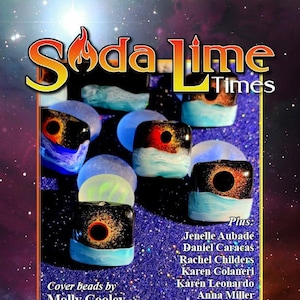 May include: A magazine cover for Soda Lime Times, featuring a colourful galaxy background with stars and a title in gold lettering. The cover features a collection of glass beads with black and white swirling patterns and a dark centre. The text "Cover beads by Molly Cooley" is at the bottom of the cover. The magazine is for June 2021.