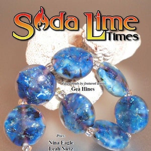 Puede incluir: Una portada de revista para Soda Lime Times, que presenta un primer plano de un collar hecho de cuentas de vidrio azul y morado. El texto de la portada de la revista dice "Soda Lime Times" y "Abril 2020".