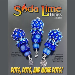 May include: Three blue glass beads with white and black dots, each bead is attached to a silver wire with a spiral at the bottom. The beads are arranged in a row, with the largest bead in the middle. The beads are featured in the July 2018 issue of Soda Lime Times magazine. The magazine cover text reads "DOTS, DOTS, AND MORE DOTS!"