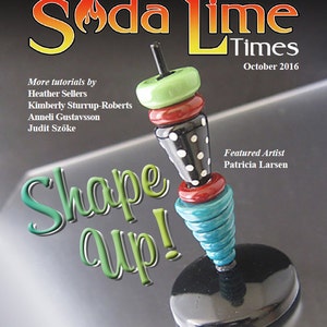 May include: A magazine cover for Soda Lime Times, October 2016, featuring a colourful, hand-crafted, glass spinning top with a black and white polka dot design. The magazine cover text reads "Shape Up!" and features the name of the featured artist, Patricia Larsen.