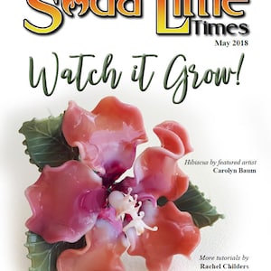 May include: A close-up of a pink glass hibiscus flower with green leaves. The flower is made of glass and has a realistic appearance. The image is from the Soda Lime Times magazine, May 2018, and features the text "Watch it Grow!" and "Hibiscus by featured artist Carolyn Baum".