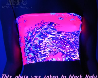 May include: A pink and blue swirl pattern tube top with a black background. The top is made of a stretchy fabric and is designed to be worn as a crop top. The photo was taken under a black light, which makes the colours glow.