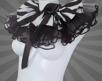 Puede incluir: Un collar con lazo a rayas blancas y negras con un ribete de tul negro, exhibido en un maniquí blanco. El collar tiene un lazo grande y una cinta de satén. El nombre de la tienda Etsy MTcoffinz.ETSY.com es visible en la parte inferior.