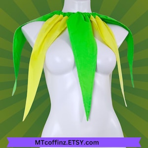 May include: A green and yellow jester collar displayed on a white mannequin. The collar has long, pointed, alternating green and yellow fabric pieces. The text "MTcoffinz.ETSY.com" is displayed at the bottom of the image.