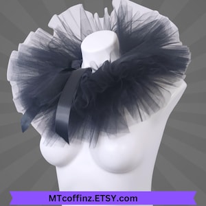May include: A black tulle collar with a satin ribbon bow, displayed on a white mannequin. The collar has a layered design and is set against a gray background. The text "MTcoffinz.ETSY.com" is at the bottom.