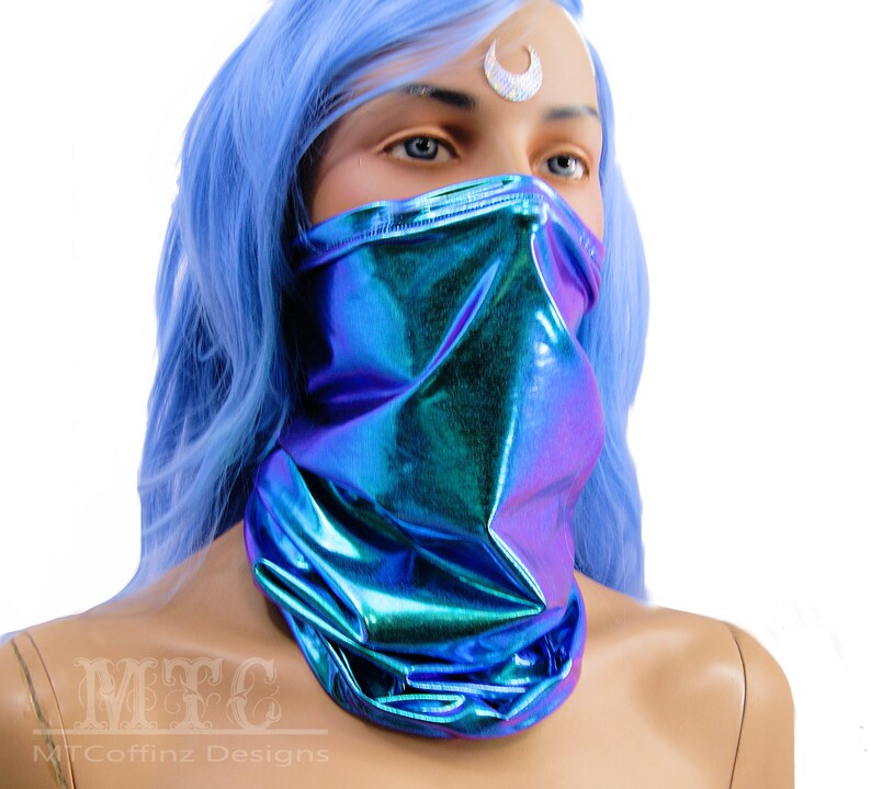 May include: A blue iridescent face mask made of stretchy fabric. The mask is worn by a mannequin with blue hair.