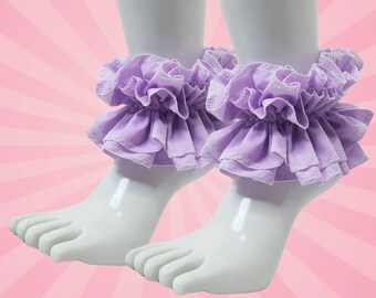 May include: A pair of lavender ruffle ankle cuffs. The cuffs are made of soft fabric and have a delicate, feminine look.