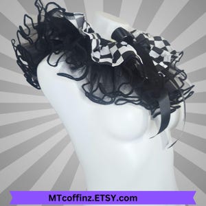 May include: A black and white chequered collar with black tulle ruffles and a black satin bow. The collar is displayed on a white mannequin. The Etsy shop name MTcoffinz.Etsy.com is displayed on a purple banner.