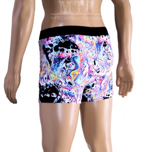 Puede incluir: Pantalones cortos tipo b&oacute;xer con un vibrante patr&oacute;n arremolinado en tonos rosa, azul, amarillo y negro. Los pantalones cortos tienen una cintura negra y un dise&ntilde;o abstracto colorido. El texto "MTCoffinz Design" es visible en la parte superior.