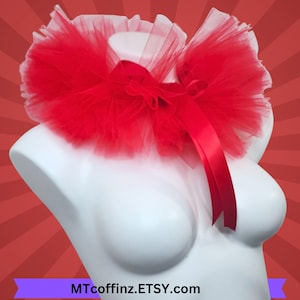 May include: A red tulle collar with a satin ribbon bow, displayed on a white mannequin. The collar is layered and fluffy, creating a voluminous effect. The Etsy shop name, MTcoffinz.Etsy.com, is visible at the bottom.