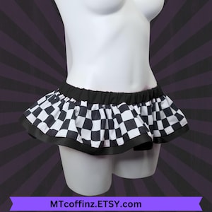 May include: A black and white checkered mini skirt with a black waistband and trim. The skirt is displayed on a white mannequin. The Etsy shop name MTcoffinz.ETSY.com is displayed at the bottom of the image.