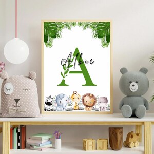 May include: A green letter A with a leafy vine, the name Albie written above it, and a row of jungle animals below. The animals include a zebra, elephant, giraffe, lion, and hippopotamus. The background is white with green palm leaves.