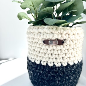 May include: A white ceramic mug with a black handle and the text "But First, Coffee" in a handwritten style. The mug is on a white surface. The mug is 4 inches tall.