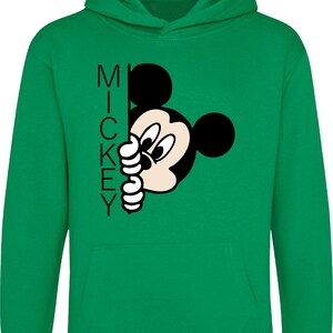 Puede incluir: Sudadera con capucha verde con una imagen de dibujos animados en blanco y negro de Mickey Mouse asom&aacute;ndose por detr&aacute;s de la palabra "MICKEY".