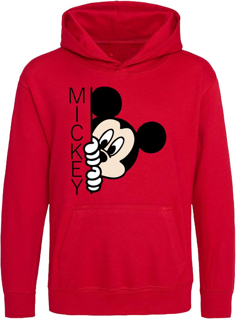 Puede incluir: Sudadera con capucha roja con una imagen de dibujos animados en blanco y negro de Mickey Mouse asom&aacute;ndose por detr&aacute;s de la palabra "MICKEY".