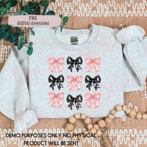 May include: A gray sweatshirt with a design of pink and black bows with ghost patterns. The text "DEMO PURPOSES ONLY NO PHYSICAL PRODUCT WILL BE SENT" is at the bottom of the image.