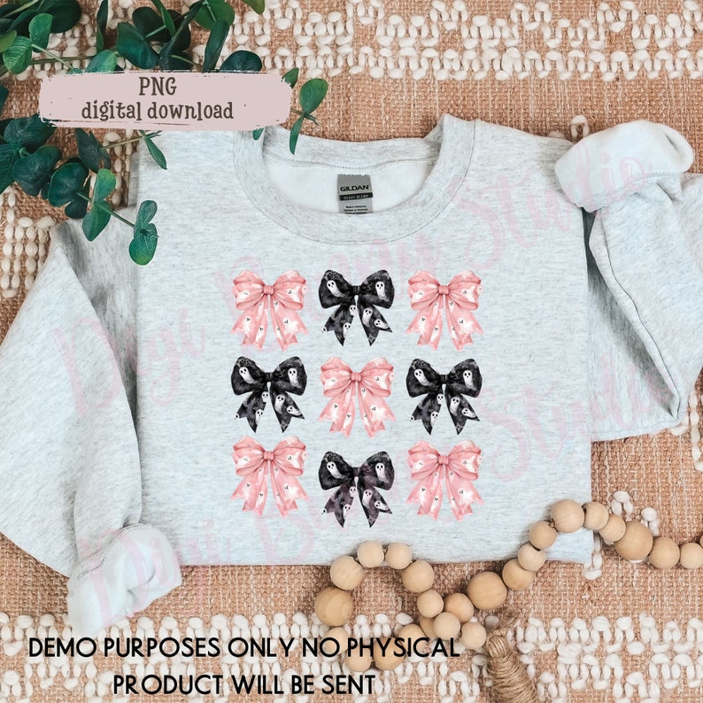 May include: A gray sweatshirt with a design of pink and black bows with ghost patterns. The text "DEMO PURPOSES ONLY NO PHYSICAL PRODUCT WILL BE SENT" is at the bottom of the image.