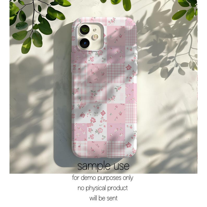 以下が含まれることがあります： ピンクと白のパッチワークの携帯電話ケース。花柄とチェック柄のデザイン。ケースは正方形で、カメラの切り抜きがあります。「sample use」というテキストとその他のテキストが下部に表示されています。