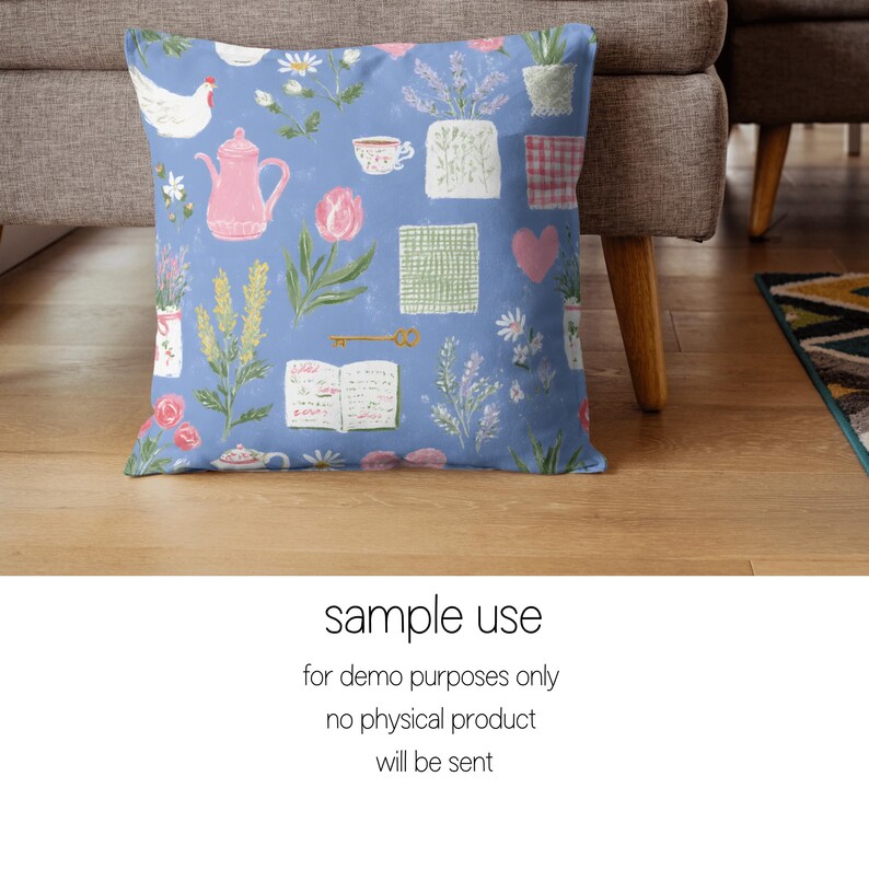 Pode incluir: Uma almofada quadrada com fundo azul claro e um padr&atilde;o de bules rosa, flores e x&iacute;caras de ch&aacute;. A almofada tamb&eacute;m apresenta uma galinha branca, um livro e o texto "sample use".